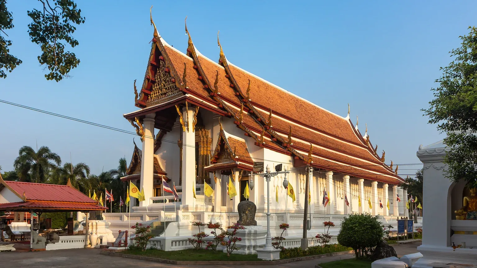 พระอุโบสถวัดหน้าพระเมรุมองจากด้านข้าง เห็นหลังคากระเบื้องดินเผาซ้อนชั้น มุขหน้า หน้าบันปิดทอง และเสาพาไลเรียงตลอดแนวผนัง