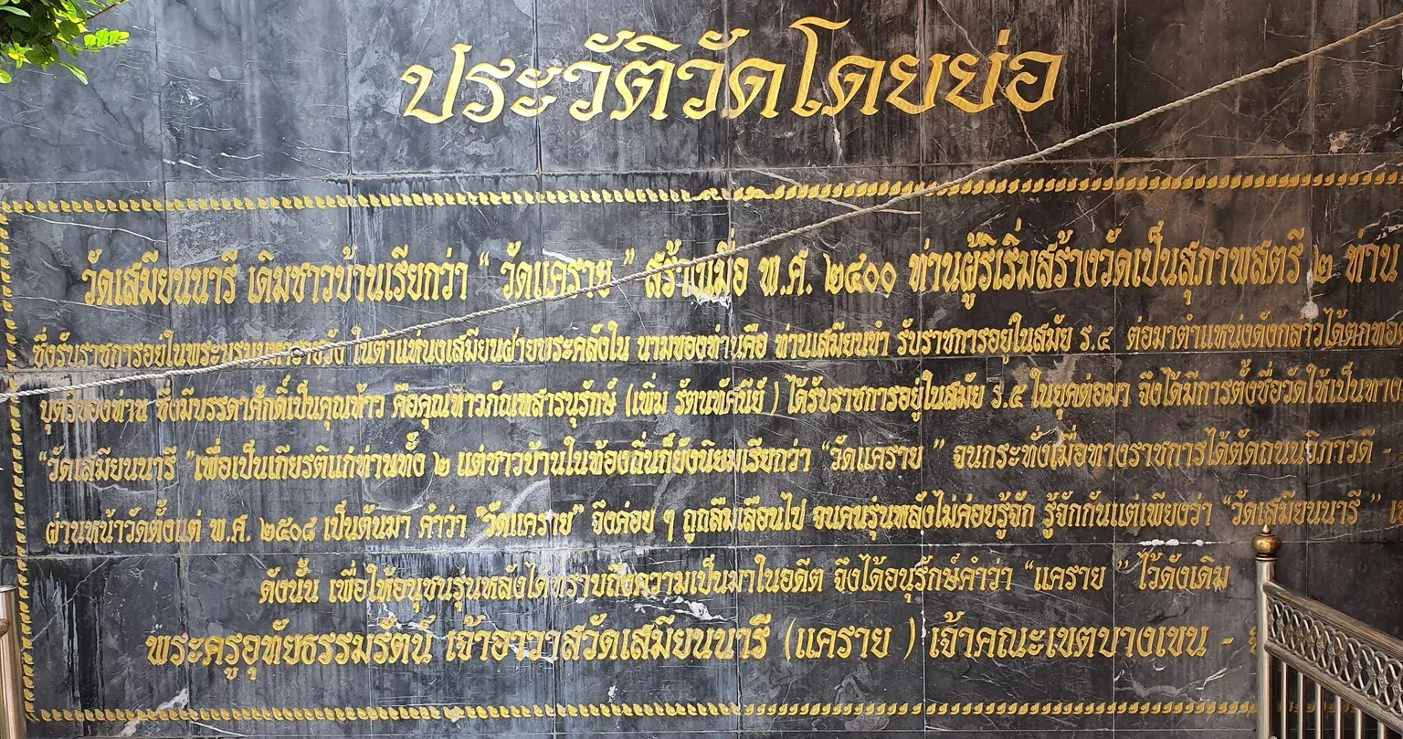 ป้ายหินสีดำตัวอักษรสีทอง ประวัติวัดโดยย่อ ภายในวัดเสมียนนารี เล่าที่มาของชื่อวัดแครายและวัดเสมียนนารี