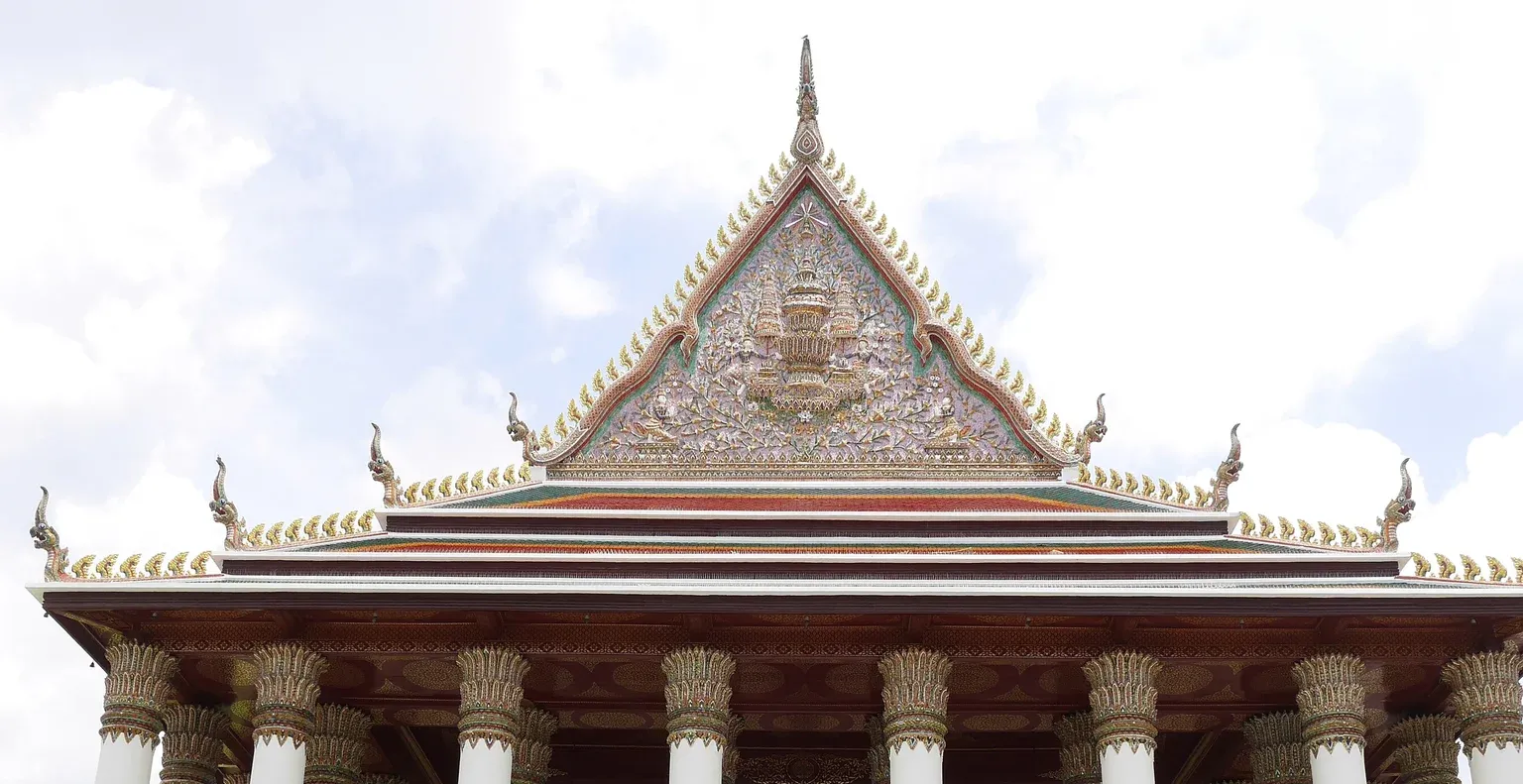 หน้าบันพระอุโบสถวัดเทพศิรินทราวาส ลายพรรณพฤกษาสีทอง ช่อฟ้าและนาคที่มุมหลังคา กับหัวเสากลีบบัวของเสาพาไล